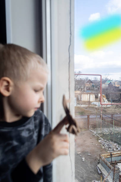 istock Child sits on the window and holding a fighter toy plane 1381265322