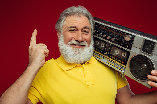 Old man holding with cassette boom box enjoying music
