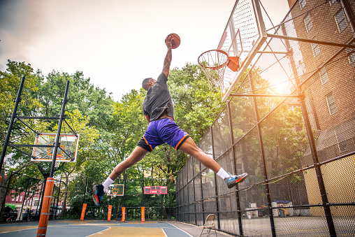 Afro-american basketball player training on a court in New York - Sportive man playing basket outdoors