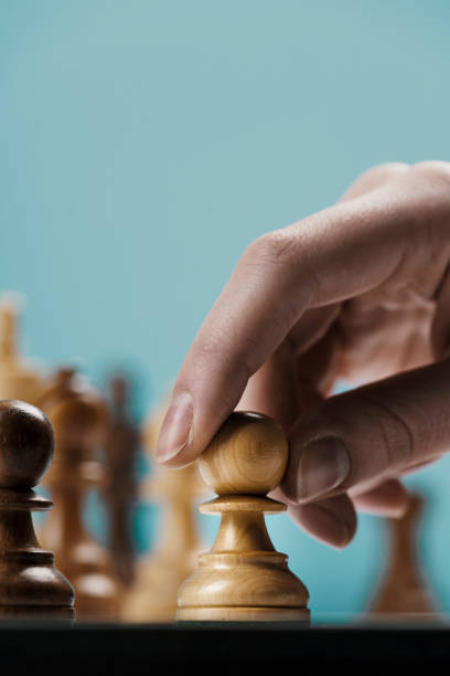istock Player moving a pawn on the chessboard 1381306747
