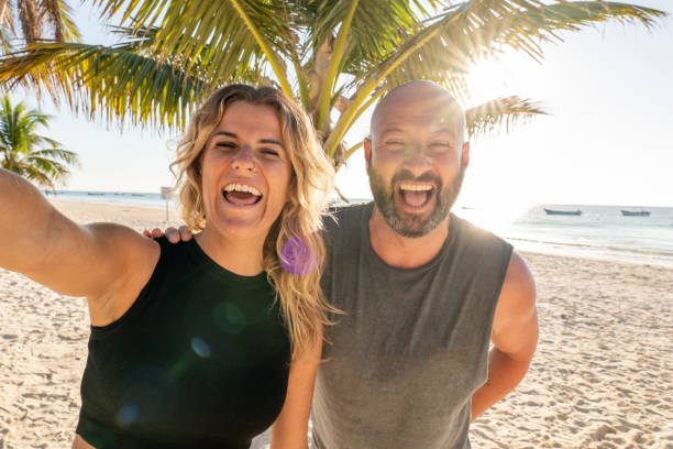 istock Couple taking selfie on the beach at sunset or sunrise 1381307280