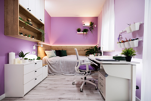 Modern luxury teenage girl's bedroom with desk and lot of plants. Bright wooden floor and lot of lamps. 
Canon R5.