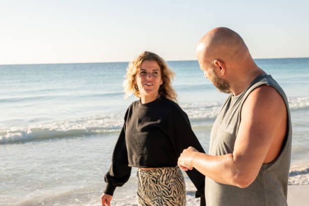 istock Couple walking on the beach at sunrise enjoying nature 1381311708
