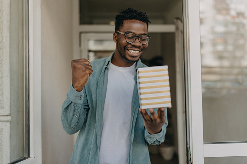 Young  African-American man is overjoyed to receive gift he has been waiting for