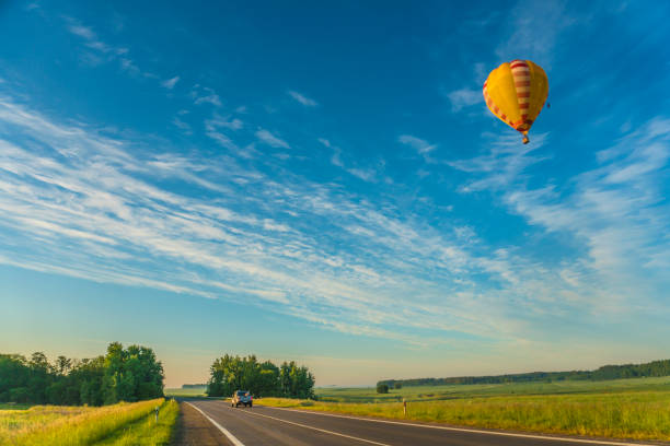 istock hot air balloon flying over the road 1381346955
