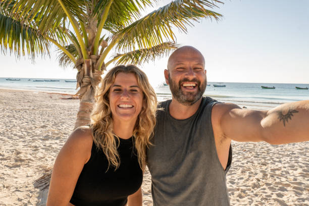 istock Couple taking selfie on the beach at sunset or sunrise 1381351182