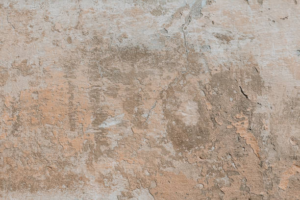 istock Plastered weathered wall with detailed texture. Beige grunge background. A concrete surface with damages. 1381381713