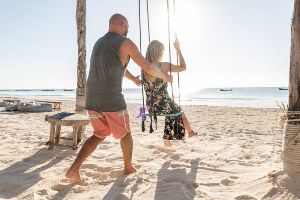 istock Couple playing with swings on the beach 1381399493