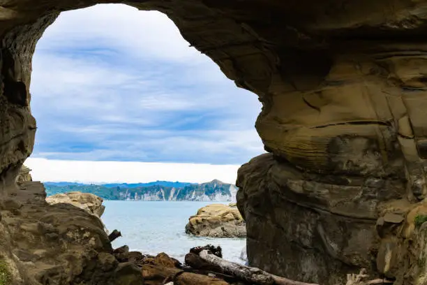 Blue water of Tolaga Bay through Hole in the Wall tourist destination and landmark on East Coast New Zealand.