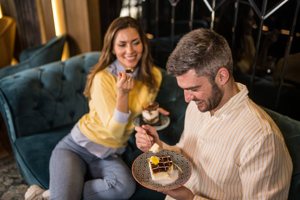 istock Happy couple eating cakes together in a cafe. 1381408229