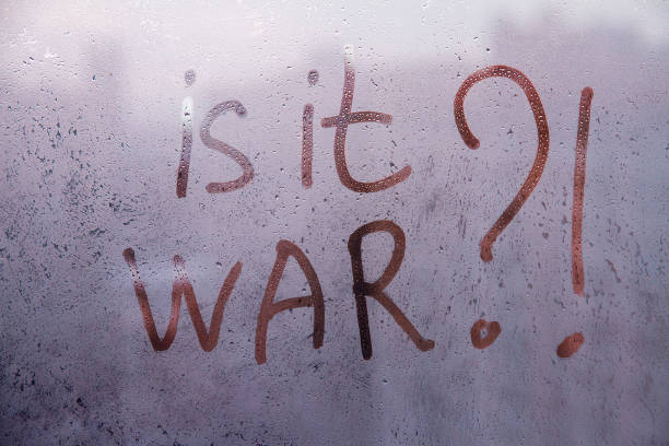 istock Red question Is it war are painted handwriting on dark violet window with raindrops 1381408783