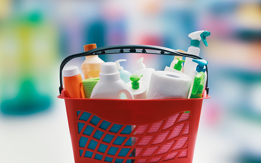 Red shopping basket with cleaning products and blank copy space, hygiene and housekeeping concept