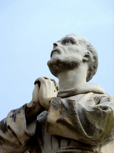 istock White statue of a praying monk viewed from under 1381421828