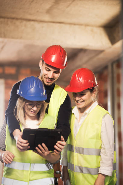 istock team of engineers in vests and hard hats with in a tablet, on a construction site 1381421871