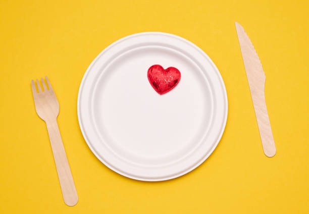 white plates on a yellow background. Recyclable garbage, rejection of plastic, top view