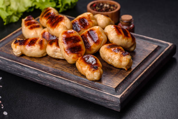 istock Grilled sausages with spices on a dark stone background 1381451367