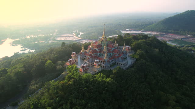 Aerial Drone Sunset Scene of Phra Mahathat chedi Pakdee Prakard in Prachuap Khiri Khan, Thailand, Located on the top of the Thong Chai mountain. It was built to commemorate the 50th anniversary of the reign of His Majesty King Bhumibol Adulyadej, Rama IX.