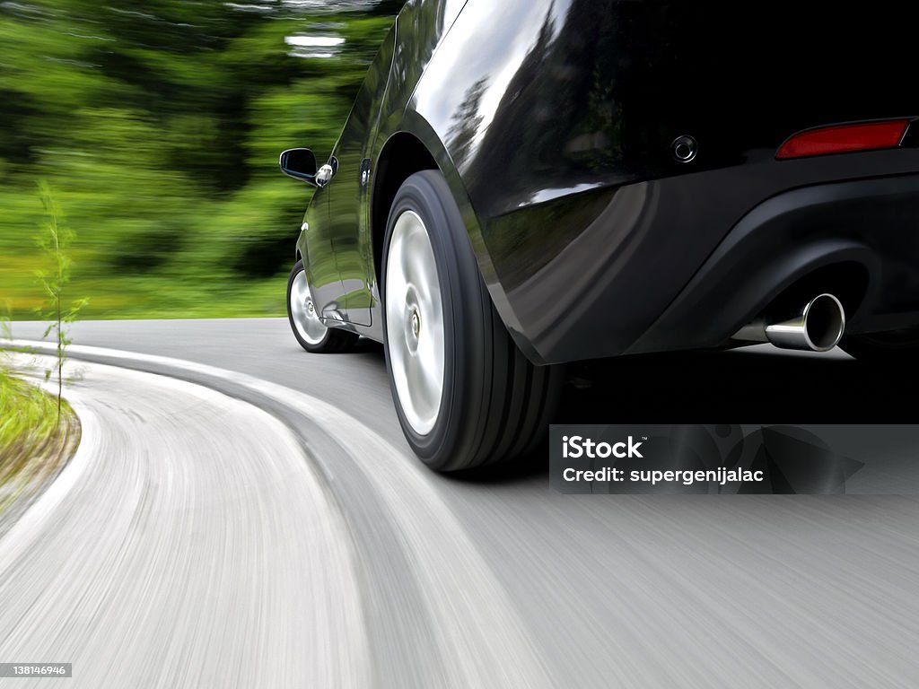 Driving a car Low angle, rear wheel motion blur shot of a sports car driving fast in a curve Car Stock Photo