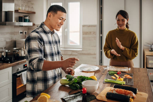 istock Japanese couple preparing sushi at home 1381469901
