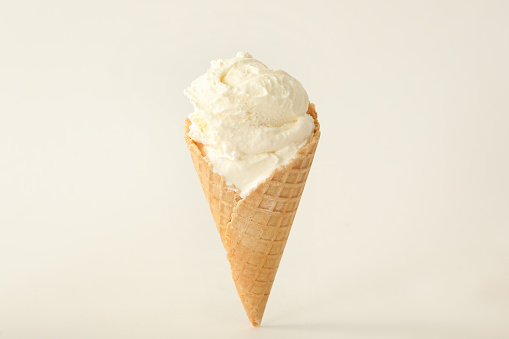 Delicious ice cream in waffle cone on white background