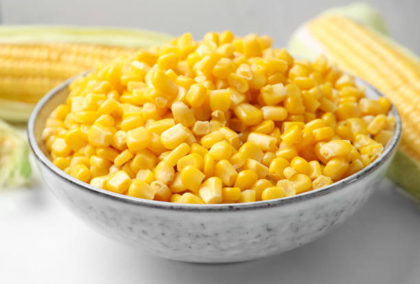 istock Bowl of preserved corn on white table, closeup 1381479326