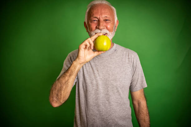 istock Smile senior man portrait with green apple 1381482701