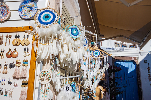 'Evil Eye' (Mati) in Pyrgos Kallistis in Santorini, Greece. Other commercial items are visible uin the background. The eye is meant to ward off malicious curses from jealous people.