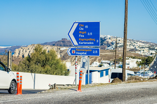 Road Sign on Santorini in South Aegean Islands, Greece, with cars and commercial symbols visible