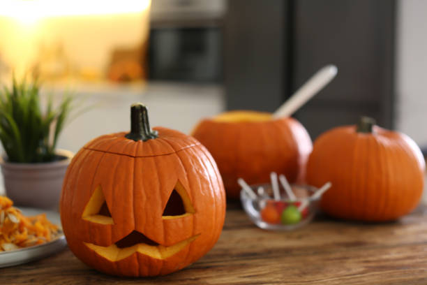 istock Pumpkin jack o'lantern on wooden table indoors, space for text. Halloween celebration 1381509681