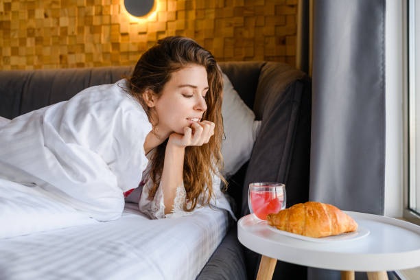 istock Girl covered with a blanket is going to have breakfast in bed 1381549859