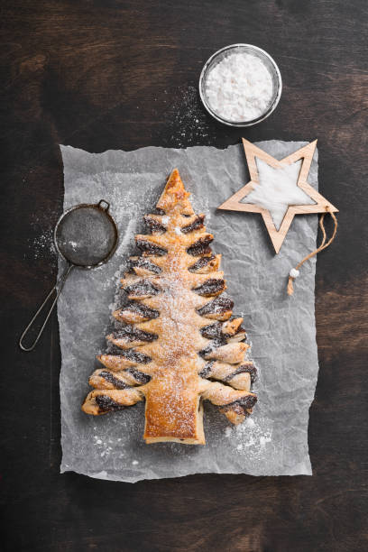 istock Puff pastry Christmas tree with chocolate paste, sprinkled with powdered sugar on old dark wooden background. Christmas or Xmas pastries. Top view. Copy Space 1381571342