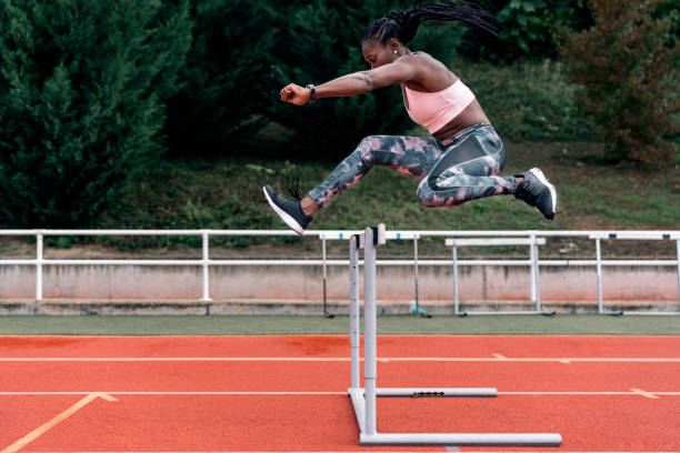 istock African-American athlete sprinter jumping a hurdle 1381574275
