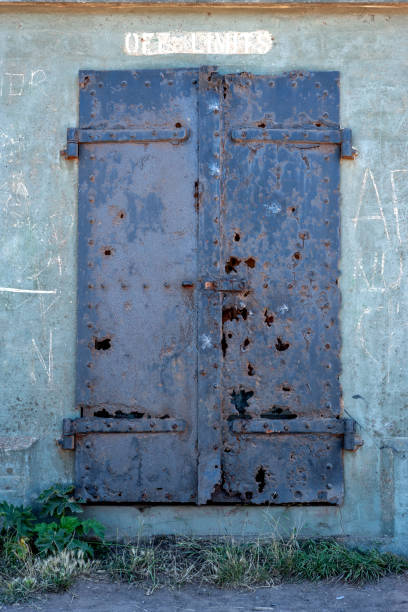 old black rusty metal door at concrete wall