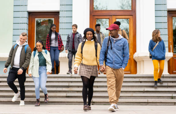 istock Multiracial couple holding hands as they leave the university 1381600817