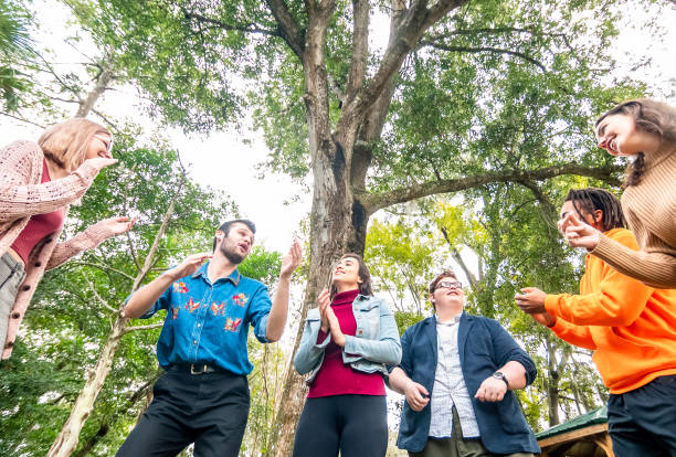 istock Diverse happy group of young people laughing clapping and singing outdoors, youth group or club or maybe team building 1381618197