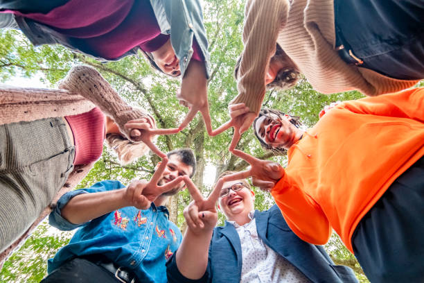 grupa młodych ludzi pokolenie z w kółku tworzy gwiazdę z palcami w znaku pokoju symbolizującym różnorodność, integrację, przyjaźń - youth organization zdjęcia i obrazy z banku zdjęć