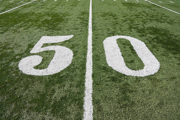 fifty yard marker on a football field stock photo