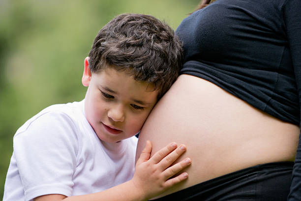 istock Boy stroking mum's pregnant belly 138165009