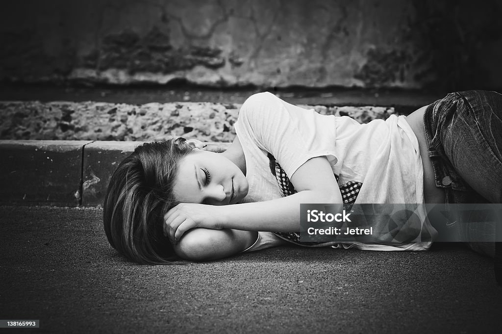 Portrait of sleeping young girl on asphalt. Black and white Portrait of sleeping young girl on asphalt. Black and white photo Adult Stock Photo