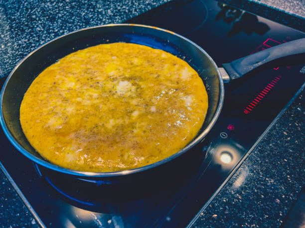 An omelet on the hob in preparation. stock photo