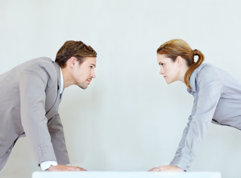 Male and female executives staring each other down