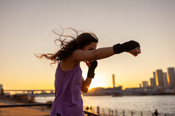 jovem boxe feminino treinando no parque público bayside na hora do pôr do sol - soco reto - boxing - fotografias e filmes do acervo