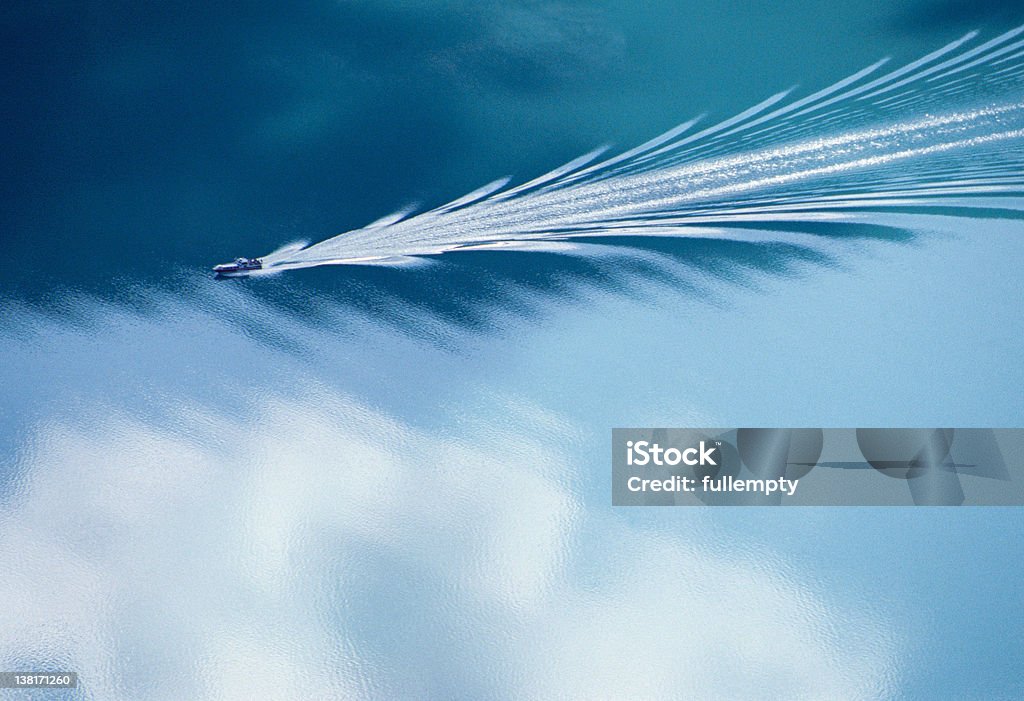 Wake of a motorboat on blue water Wake of a motorboat on blue water and reflections of sky on a lake in Norway Wake - Water Stock Photo