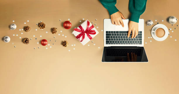 istock Christmas ornaments with person using a laptop computer 1381720979