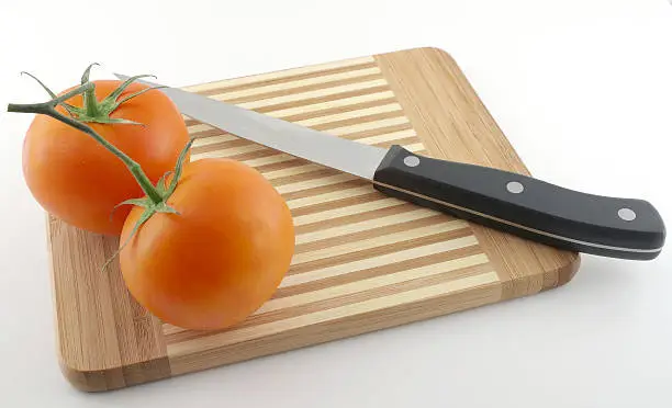 Kitchen-knife and red tomatoes on the preparation board