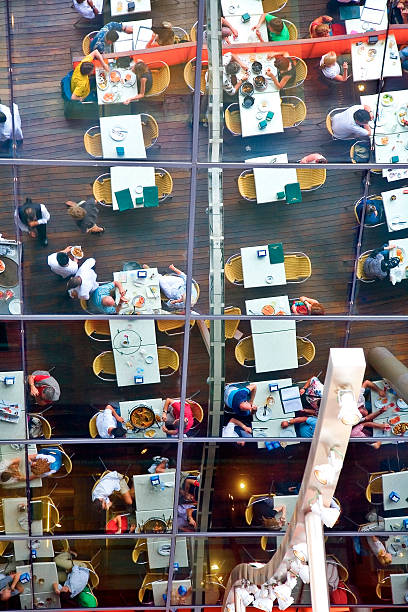 Blurred abstract background of outdoor cafe or restaurant. Outdoor cafe with tables and chairs. Street cafe in the evening in modern terrace. Customers sit at tables in a terrace area outside cafe