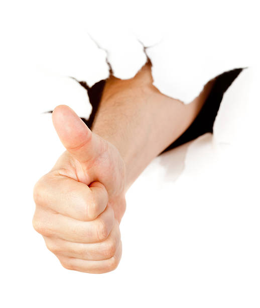 istock Hand with thumb up through a hole in paper 138175238