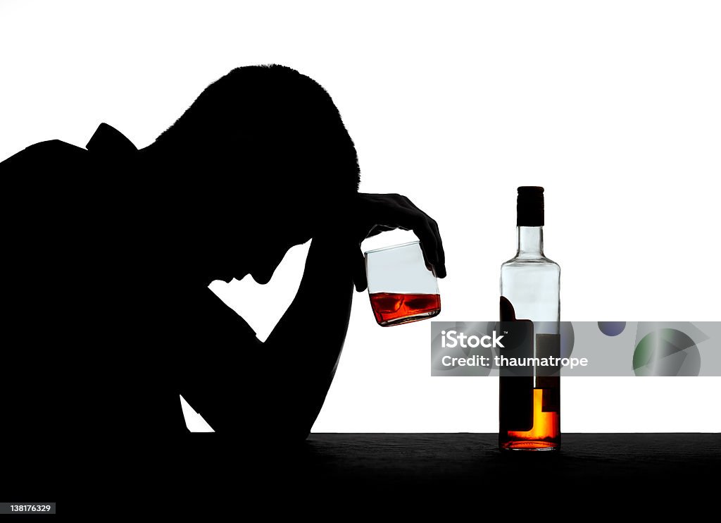 Silhouette of an alcoholic Sad man reclining on a table over his drink isolated on a white background Alcohol Abuse Stock Photo