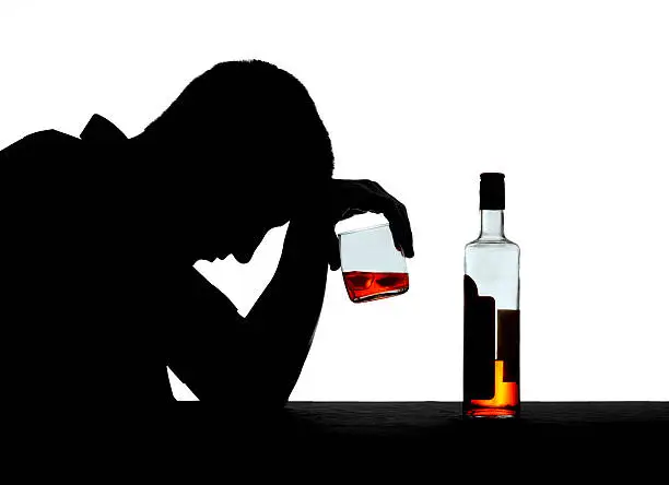 Sad man reclining on a table over his drink isolated on a white background