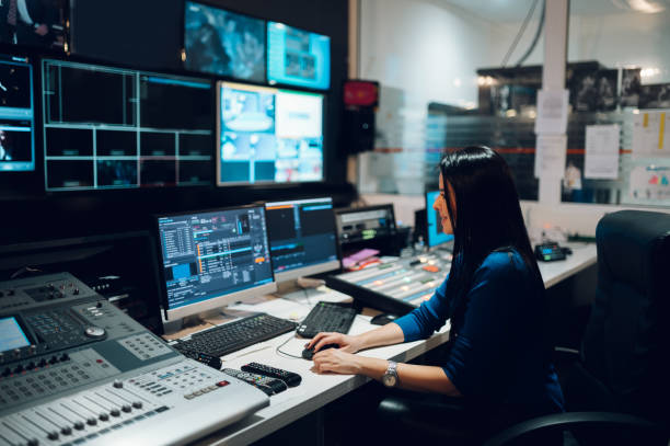 donna di mezza età che utilizza l'attrezzatura nella sala di controllo su una stazione tv - tv producer foto e immagini stock